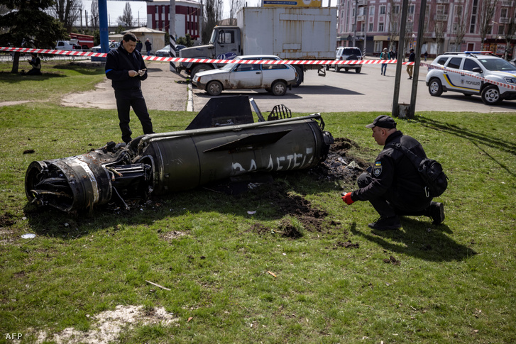 Az ukrán rendőrség átvizsgálja a kelet-ukrajnai Kramatorszk vasútállomásának főépülete mellett a rakéta maradványait 2022. április 8-án