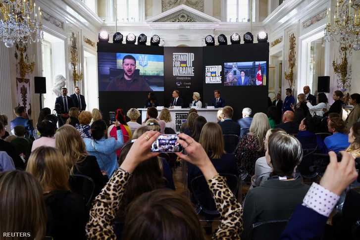 Volodimir Zelenszkij és Justin Trudeau a képernyőkön a „Stand Up For Ukraine” elnevezésű adománygyűjtő rendezvényen Ursula von der Leyennel és Andrzej Duda lengyel elnökkel 2022. április 9-én Varsóban