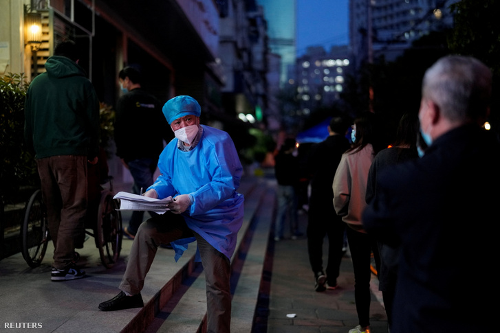 Védőruhát viselő dolgozó Sanghajban egy tesztpontnál 2022. április 9-én