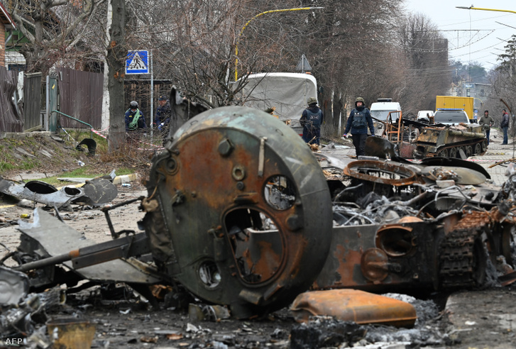 Aknamentesítést végeznek megsemmisült orosz páncélozott járművek között 2022. április 5-én Bucsában