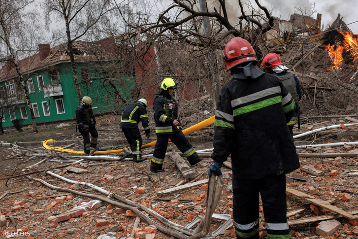 Tűzoltók egy rakétatámadást ért épületnél dolgoznak Harkovban, Ukrajnában 2022. április 12-én