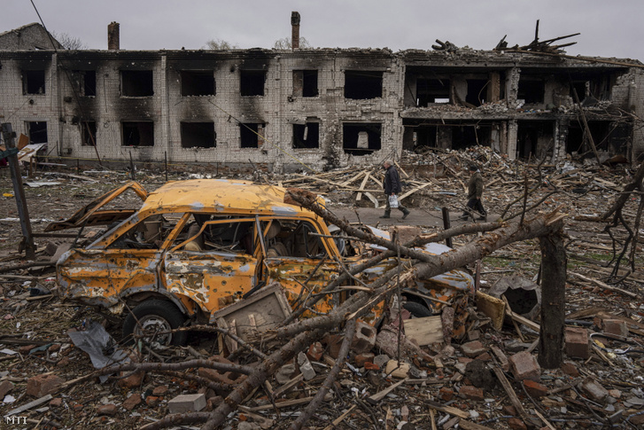 Jármű roncsa egy orosz tüzérségi támadásban megsemmisült épület előtt Csernyihivben 2022. április 13-án