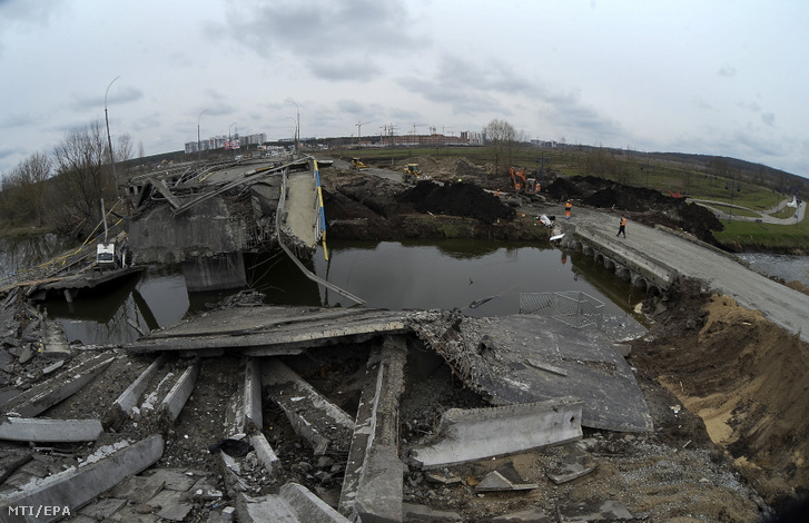 Új hidat (j) építenek az orosz támadások idején lerombolt híd mellett az ukrán hadsereg által visszafoglalt, Kijev közelében lévő Irpinyben 2022. április 10-én
