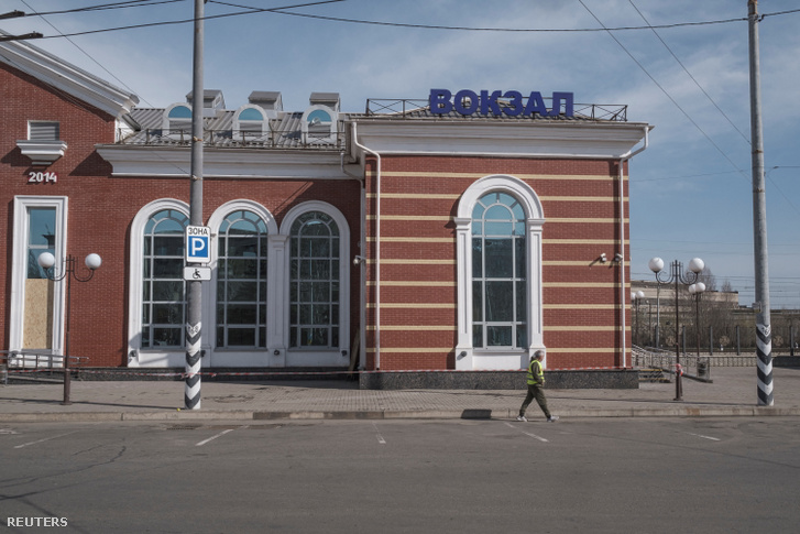 Egy önkéntes el sétál a vasútállomás előtt Kramatorszkban, Ukrajnában, 2022. április 10-én