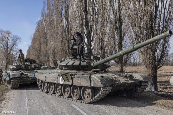 Ukrán katona áll egy orosz tank tetején egy Kijev melletti faluban Ukrajnában 2022. március 27-én