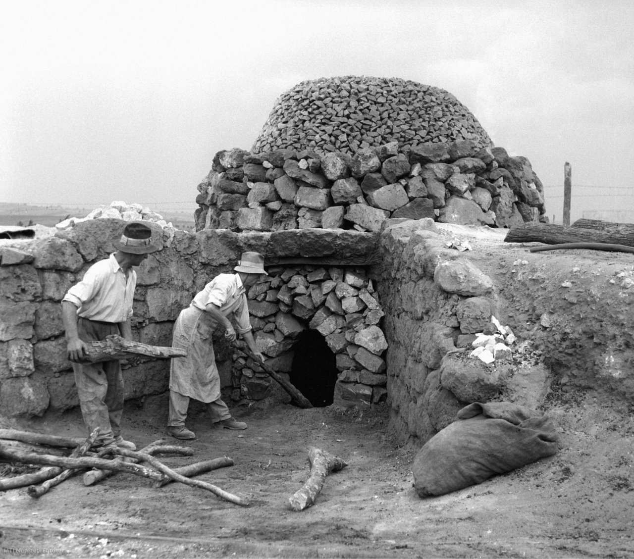 Felsőtárkány, 1956. június 17. Férfiak fával fűtik az egyik régi kemencét a felsőtárkányi Dózsa Termelőszövetkezet mészégető telepén. A telep mészégető kemencéi fafűtésről áttérnek a pakura-olaj tüzelésére.