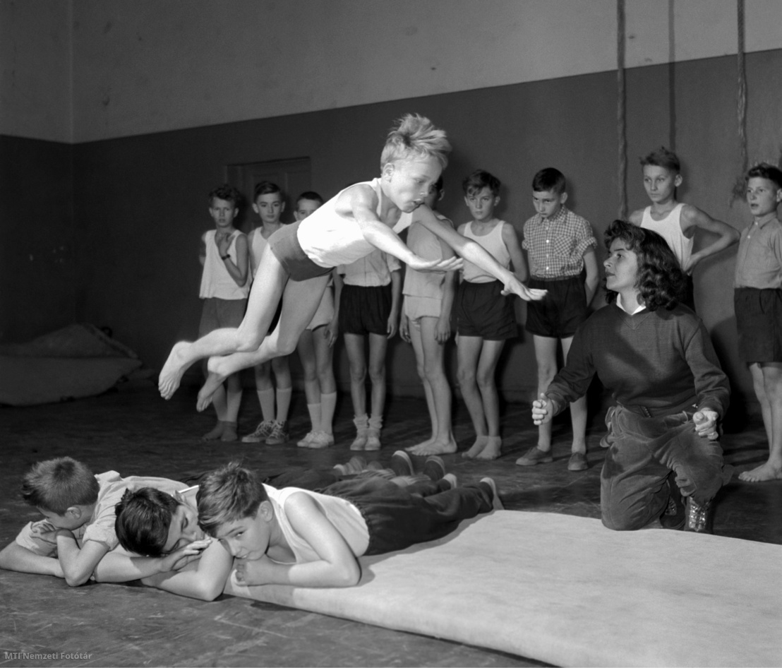 Budapest, 1957. október 23. Savolyné Peters Aliz (j), az Abonyi utcai általános iskola VI. osztályos növendékeinek tart testnevelésórát, ahol Kubicsek György tanuló gyakorlatát ellenőrzi. A tanárnő partnerével megnyerte az 1957. évi országos jégtáncbajnokságot, és a Magyar Jégrevü szólótáncosaként is fellép