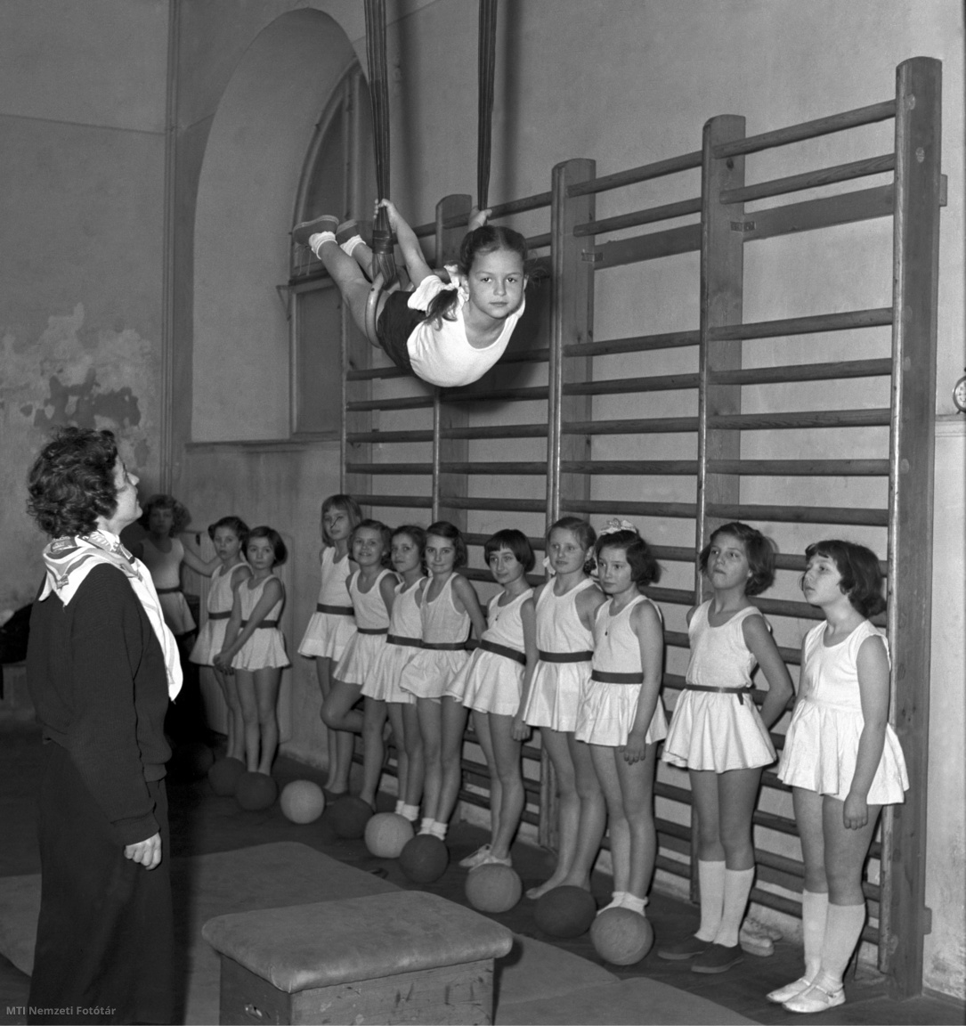 Budapest, 1955. július 30. Szabó Józsefné testnevelőtanár, minősített sífutó és a diákok egy kislány gyűrűgyakorlatát nézik a tornaórán a Szemere utcai általános iskolában