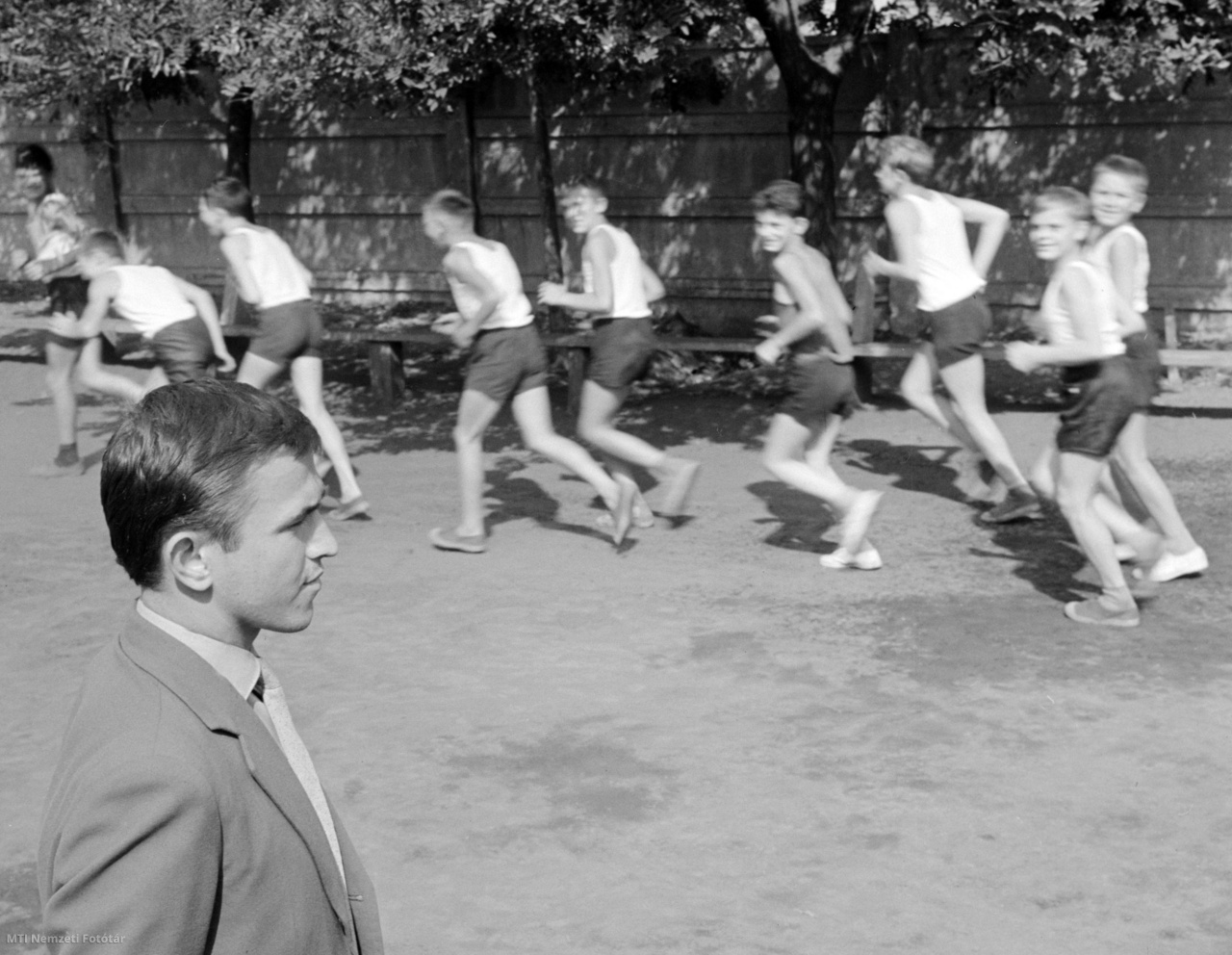 Békés, 1964. szeptember 5. Békési Mihály testnevelőtanár nézi a Békés-szécsénykerti általános iskola udvarán futó fiúkat a testnevelésórán