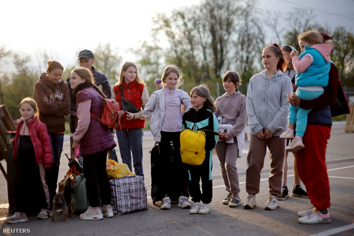 Ukrán menekült család egy menekülteknek létrehozott regisztrációs központ előtt Zaporizzsjában Ukrajnában 2022. május 2-án