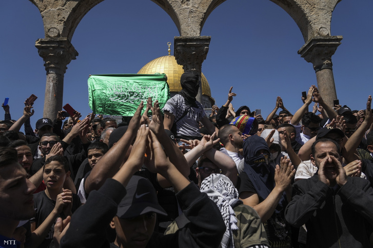 A Gázai övezetet uraló iszlamista Hamász szervezet zászlóját lengetik palesztinok a jeruzsálemi Templom-hegyen lévő Al-Aksza-mecsetnél a böjti hónap, a ramadán második péntekjén 2022. április 15-én
