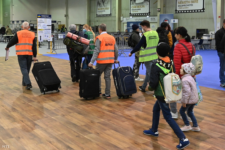 Az Ukrajnából érkezett menekülteket kísérik a pihenőhelyre a budapesti BOK csarnokban létesített humanitárius tranzitpontban 2022. április 22-én