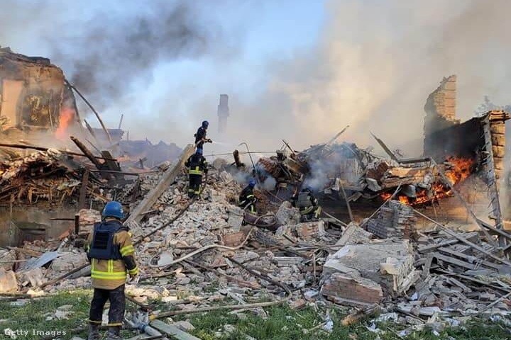 Tűzoltók oltják a tűzet egy leégett háznál a Luhanszk régióban Ukrajnában 2022. május 8-án