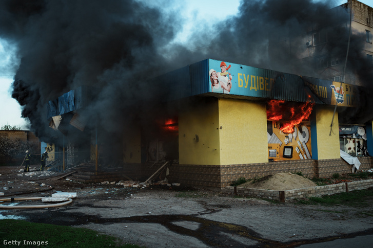 Orosz rakétatámadásban megsérült épületet oltanak ukrán tűzoltók Izjum térségben 2022. április 27-én