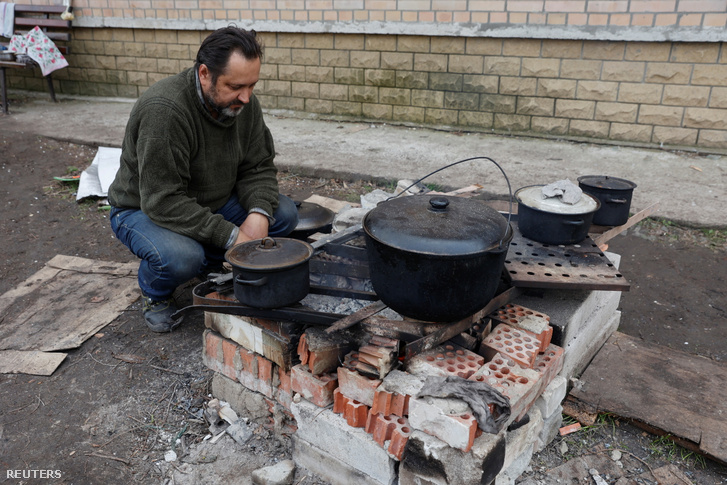Egy helyi lakos ételt készít az utcán Szeverdonyeckben 2022. április 16-án