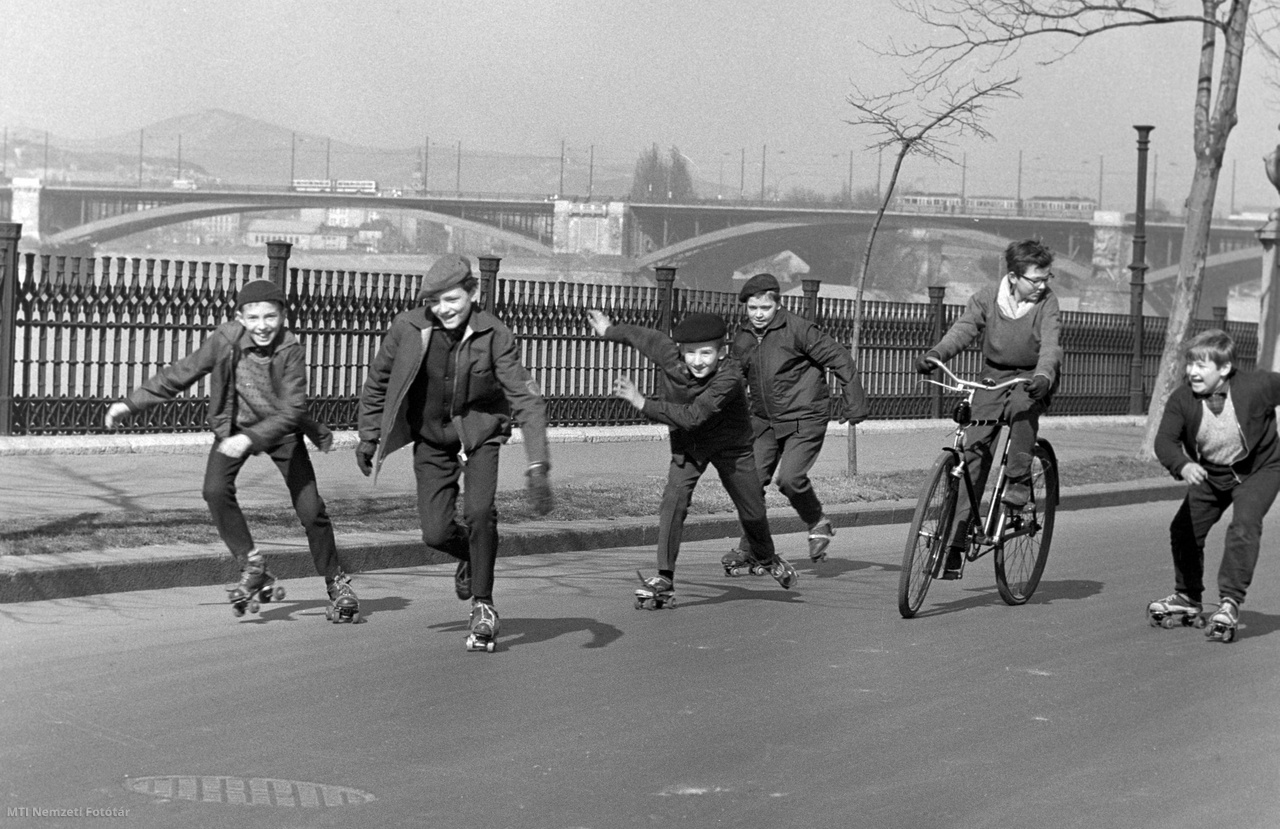 Budapest, 1968. március 1. A fiatal fiúk görkorcsolyaversenyt rendeznek a Széchenyi rakparton március első napján. Háttérben a Margit híd látható