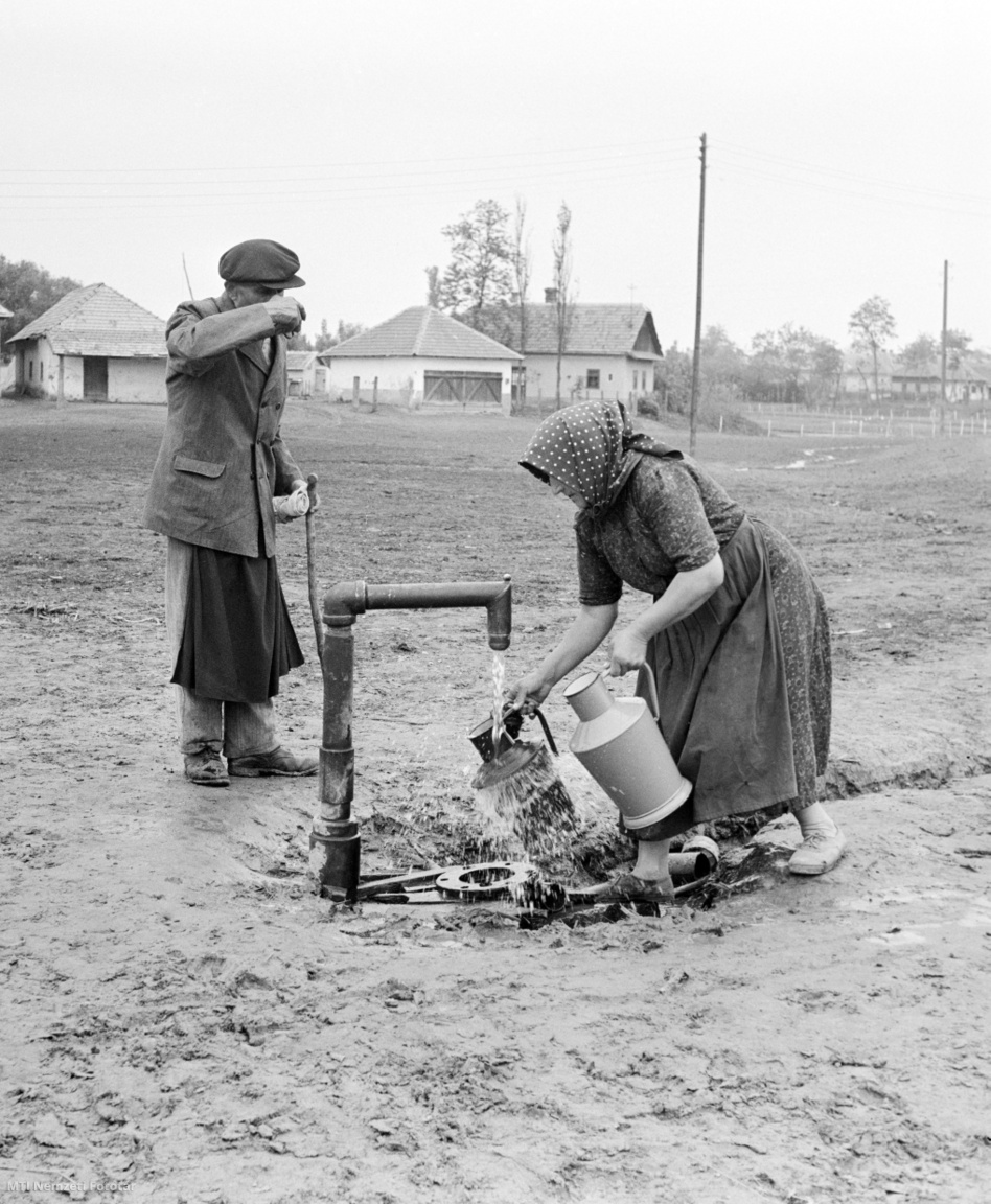 Borsodivánka, 1959. május 15. Kannáit tölti tele egy idős asszony az újonnan fúrt, meleg vizű artézi kútból, mellette egy férfi iszik a tiszta vízből Borsodivánkán