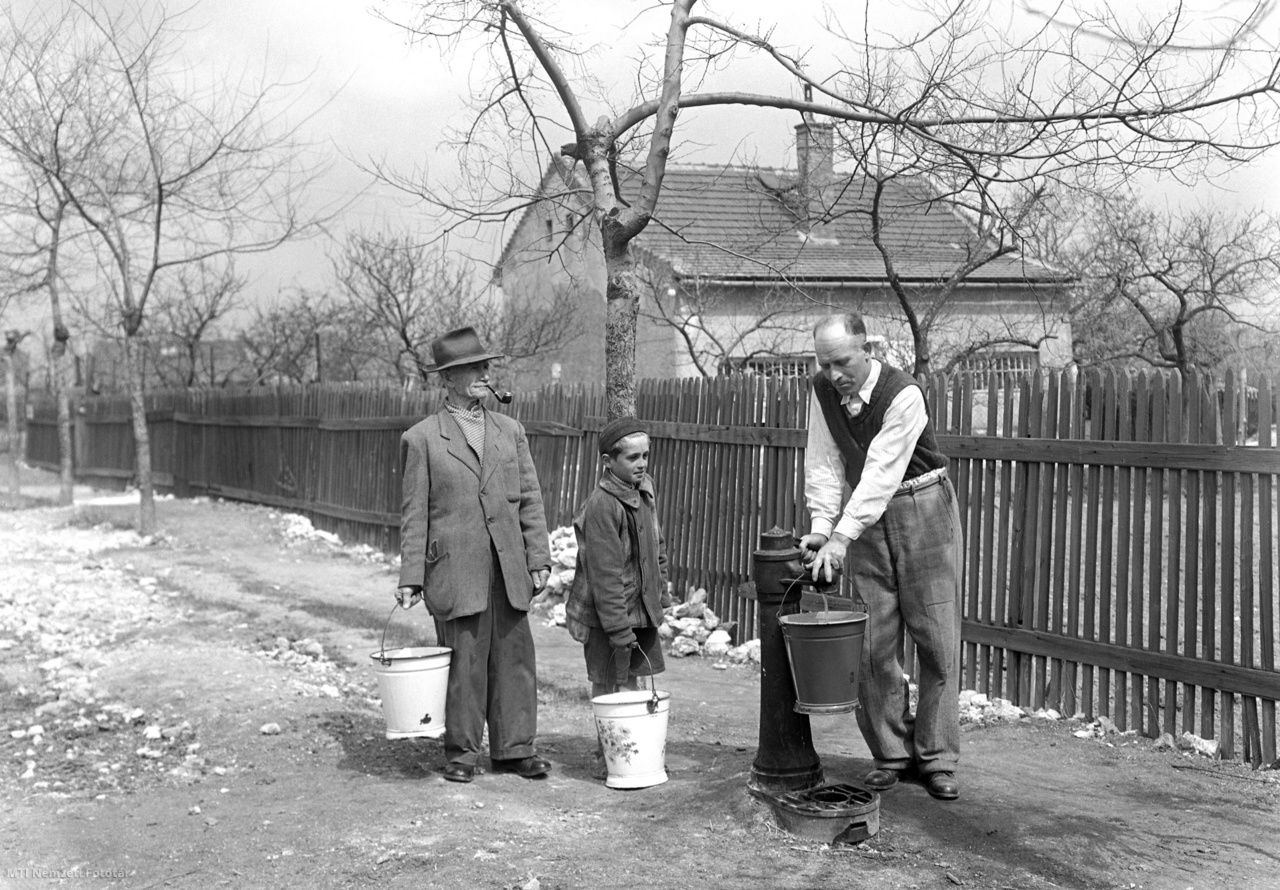 Budapest, 1954. április 12. Két férfi és egy fiú vízzel töltik meg vödreiket a budafoki Kender utcában létesített új kútnál