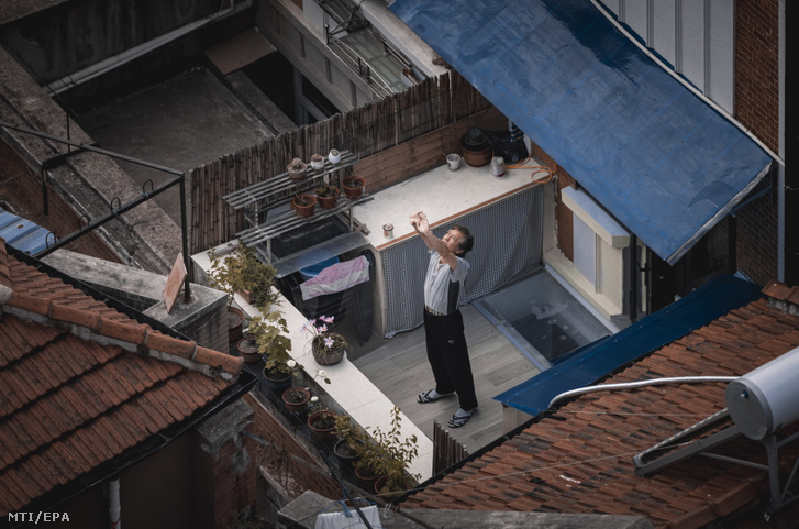 Idős férfi tornázik egy lezárt lakónegyedben, Sanghajban 2022. május 17-én