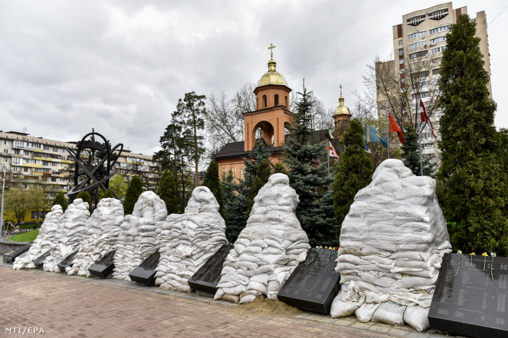 Homokzsákokkal védik az orosz tüzérségi támadásoktól a csernobili atomerőmű áldozatainak emlékművét Kijevben 2022. április 26-án
