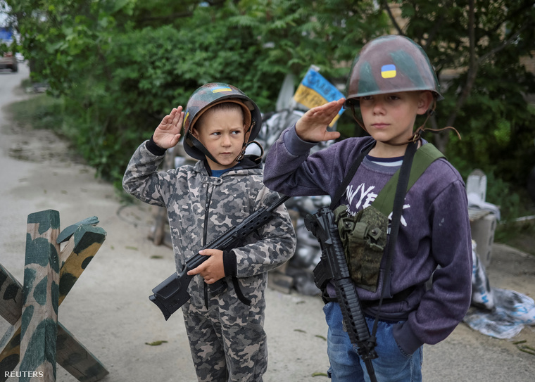A 12 éves Andrii és a 6 éves Valentyn tiszteleg, miközben ukrán katonát játszanak Sztoiankában május 22-én