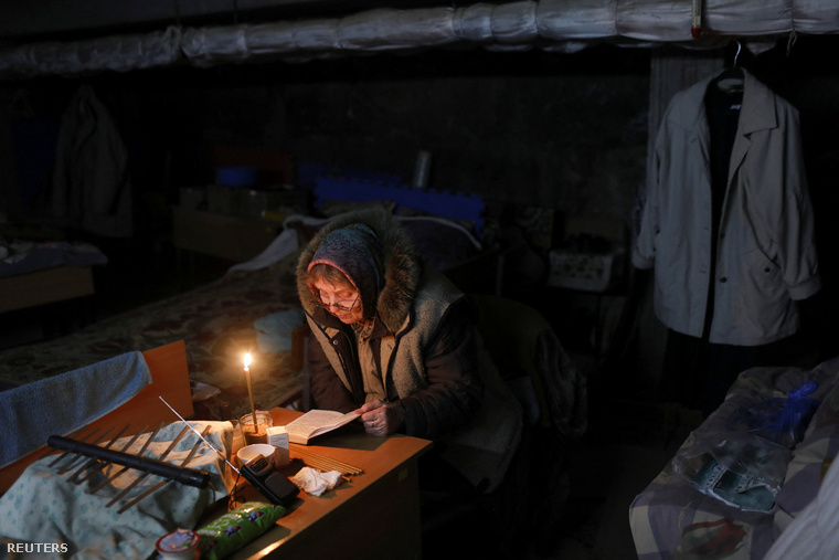 Egy nő gyertyafény mellett imádkozik Harkivban, egy Saltivka negyedben lévő iskola alagsorában május 10-én