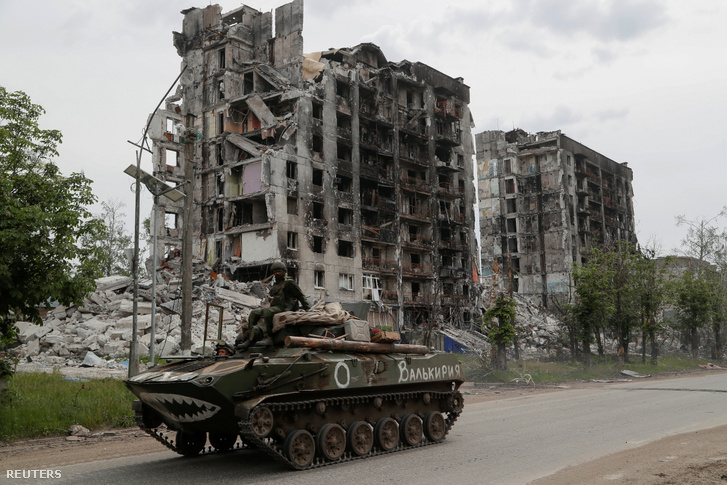 Orosz tank halad el egy lerombolt épület mellett Popasna városában, a luhanszki régióban Ukrajnában 2022. május 26-án