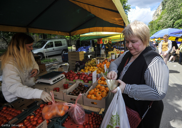 Egy nő paradicsomot vásárol a kijevi piacon Ukrajnában 2022. május 28-án