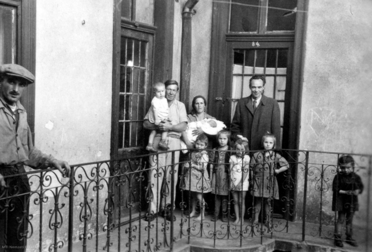 Budapest, 1947. október 9. Rajk László belügyminiszter (j) egy családdal lakásuk bejárata előtt, a házaspár újszülött gyermekének keresztapjaként.