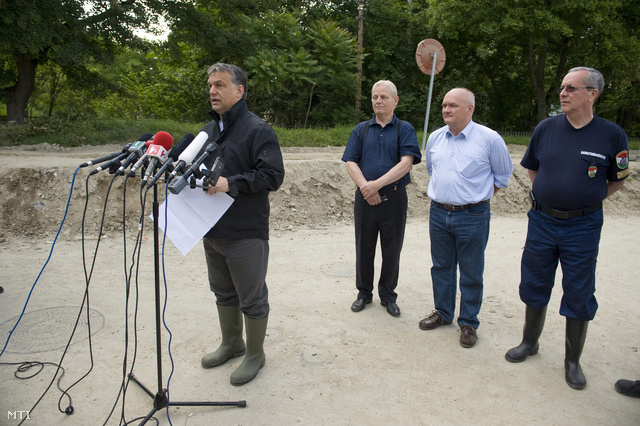 Orbán Viktor tájékoztat, mögötte Tarlós István, Hende Csaba és Bakondi György állnak sorfalat a gáton a Római partnál.