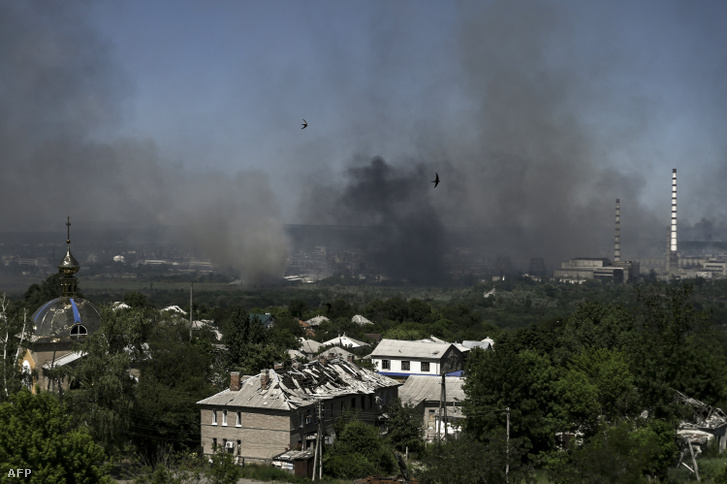 Egy megsérült épület Liszicsanszkban és Szeverodonyeck városa ahonnan fekete füst és kosz száll fel 2022. június 10-én