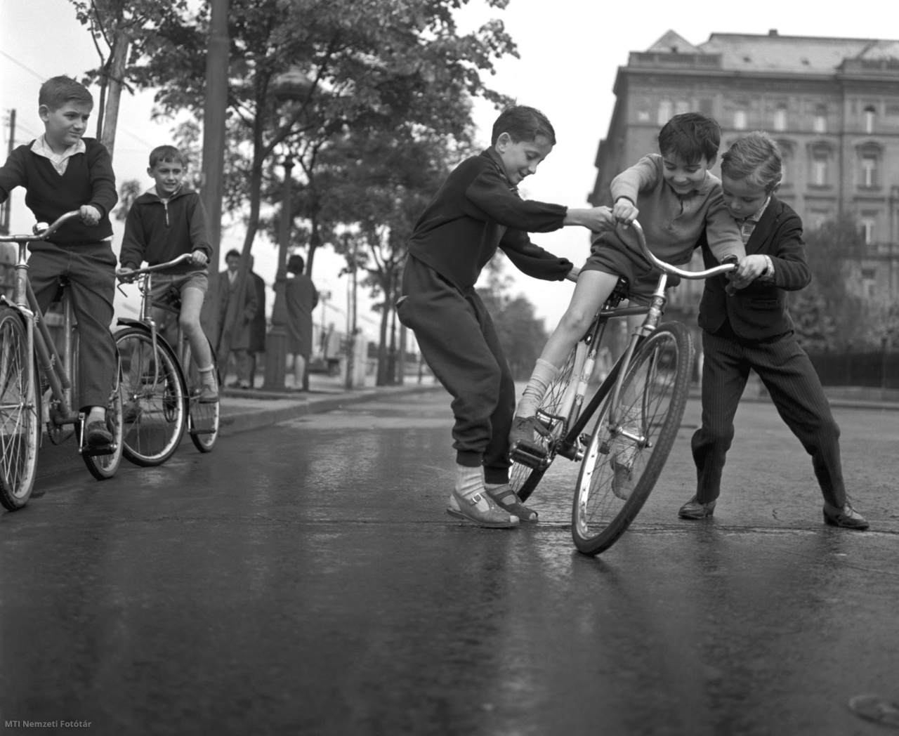 Budapest, 1964. május 22. Biciklizni tanítják a gyerekek egyik társukat a Vigadó téren.