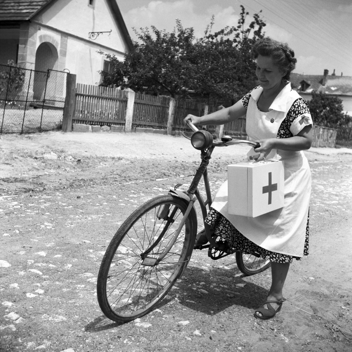 Piliscsaba, 1953. július 8. Erdélyi Józsefné Vöröskereszt aktíva kerékpáron indul az Új Barázda Tszcs (termelőszövetkezeti csoport) aratóihoz.