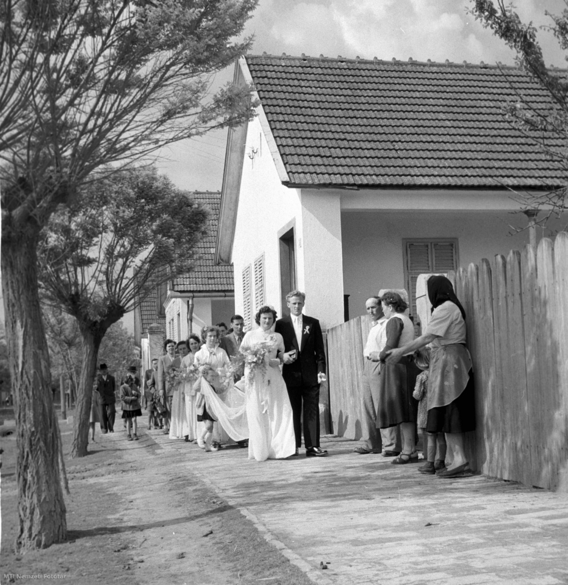 Mőzs, 1956. május 14. A fiatal pár, Izsák Ilona és Kurucz Zoltán megérkeznek a menyasszonyi házhoz tartandó falusi lakodalomra az esküvő után Mőzsön.
