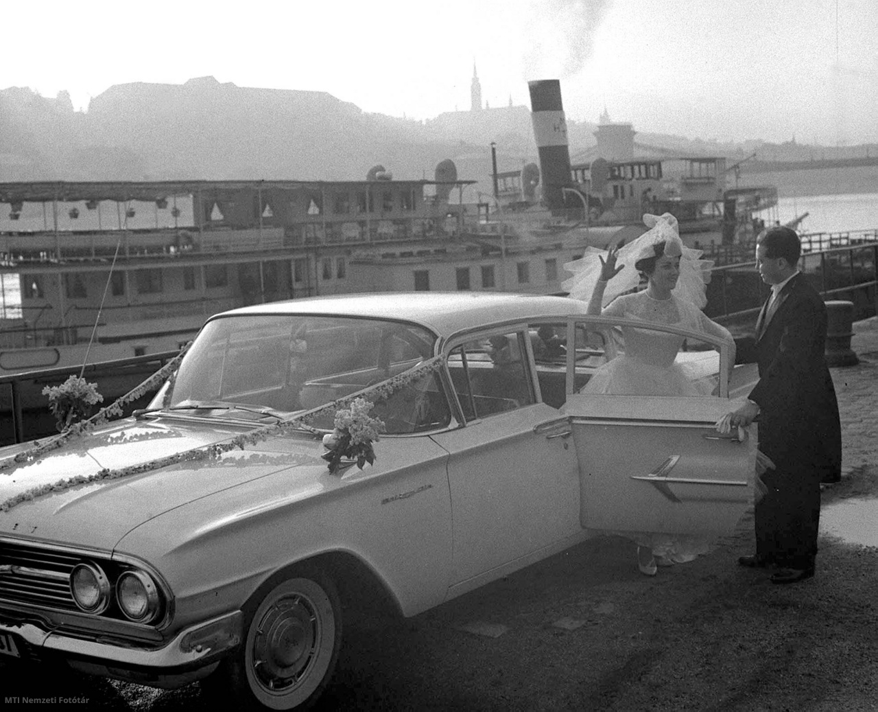 Budapest, 1963. május 4. Szilágyi János sebészorvos és Tenzlinger Ildikó, az IBUSZ (Idegenforgalmi, Beszerzési, Utazási és Szállítási Rt.) tisztviselőnője esküvőjük után fehér, nászajándékba kapott 1960-as Chevrolet Bel Air Sedan típusú gépkocsival érkezik az ünnepi vacsorára, amelyet a hajóskapitány papa ötletére a Szabadság sétahajón költenek el.