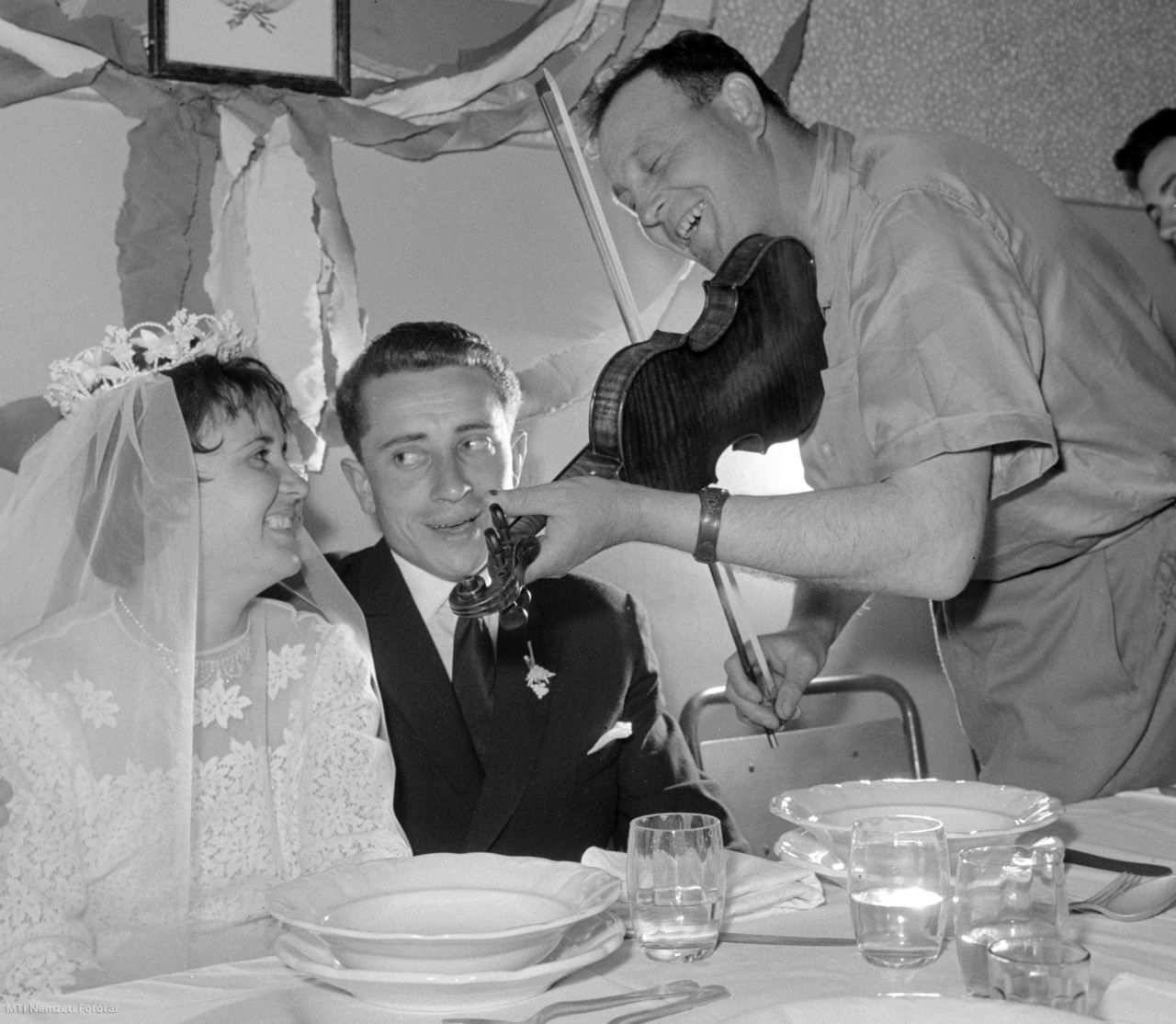 Hódmezővásárhely, 1963. május 6. A hegedűs a menyasszony kedvenc nótáját húzza Rákos Katalin, a Szántó Kovács Tsz (termelőszövetkezet) tejkezelőjének (b) és Arany Bálint, a gépállomás villanyszerelőjének (k) lakodalmán. Mindkét fiatal a "Szocialista brigád" címért versenyző brigád tagja.