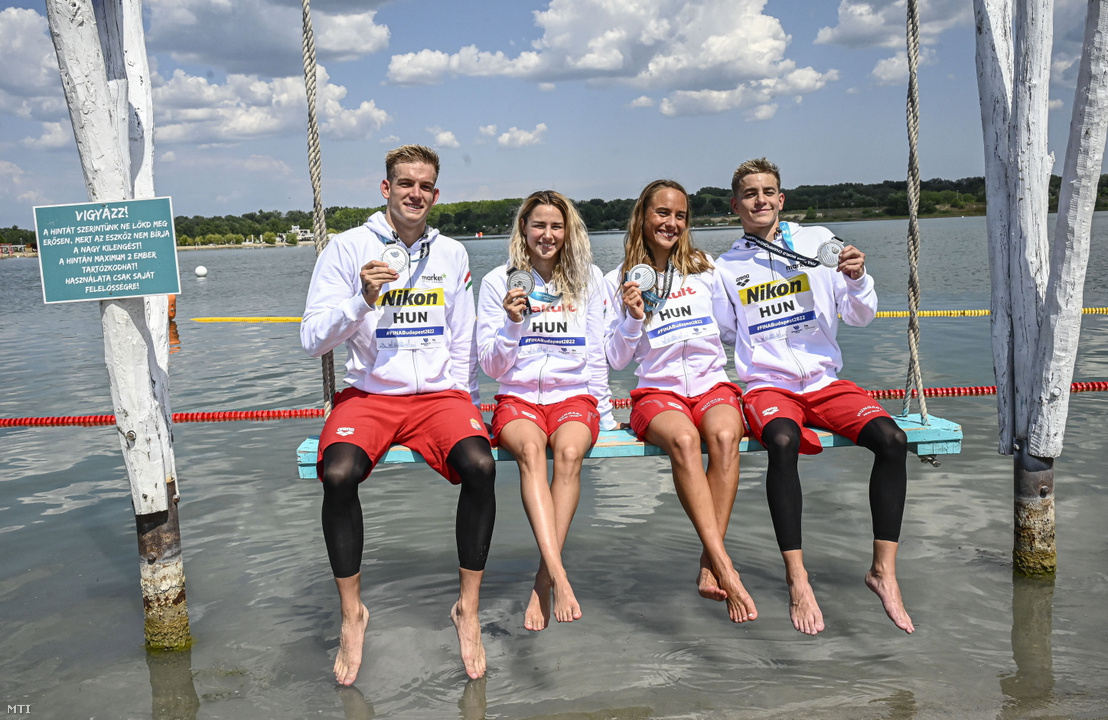 Rasovszky Kristóf, Rohács Réka, Olasz Anna és Betlehem Dávid (b-j) a második helyezett magyar válogatott tagjai a nyílt vízi úszók csapatversenyének eredményhirdetésén a budakalászi Lupa-tónál 2022. június 26-án
