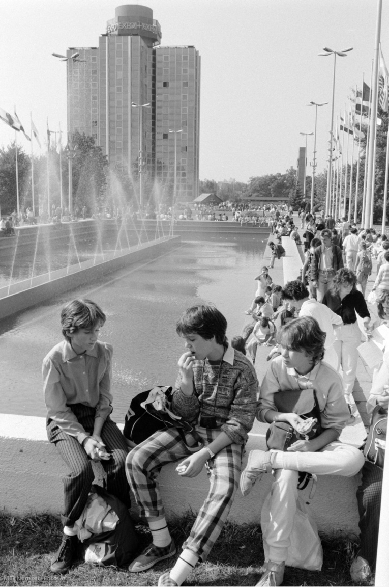 Budapest, 1988. szeptember 30. Fiatalok ülnek a Budapesti Nemzetközi Vásár (BNV) főterén lévő szökőkút padkáján. A háttérben az Expo Szálloda épülete.