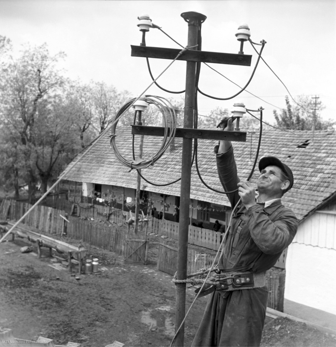 Szeged, 1953. május 7. Somlai László, a szegedi Megyevill. villanyszerelője légvezetéket szerel egy épület tetején