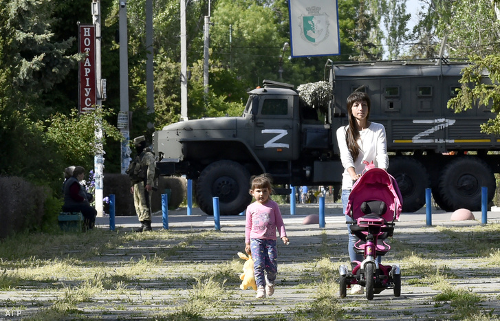 Ukrán anyuka sétál a gyerekével Herson megyében Ukrajnában 2022. május 20-án
