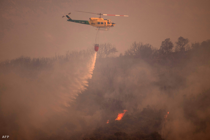 Helikopterrel oltják a tüzet a spanyolországi Sierra de Mijas hegységben 2022. július 15-én