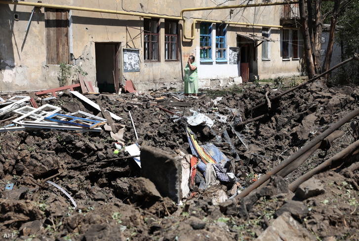 Orosz légicsapásban lerombolt háza előtt áll egy nő a donyecki régióban lévő Torecke városában 2022. július 17-én