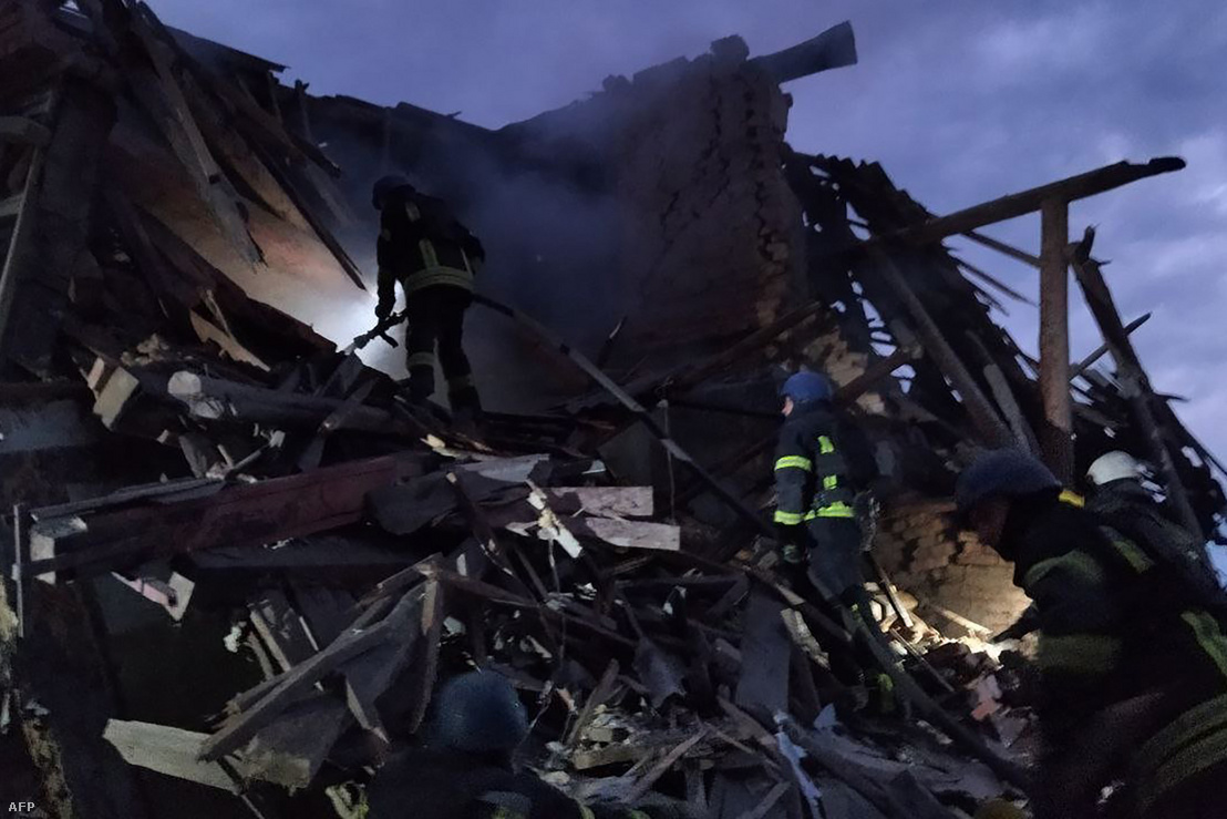 Tűzoltók oltják a tüzet egy rakétatámadásban megsemmisült épületben a Dnyipro régióbeli Nikopol városában 2022. július 16-án