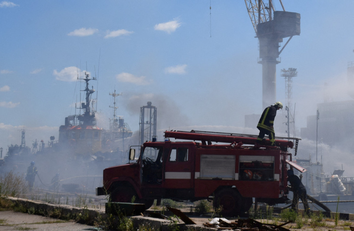 Tűzoltók dolgoznak egy rakétacsapás helyszínén Odesa egyik kikötőjében, 2022. július 23-án