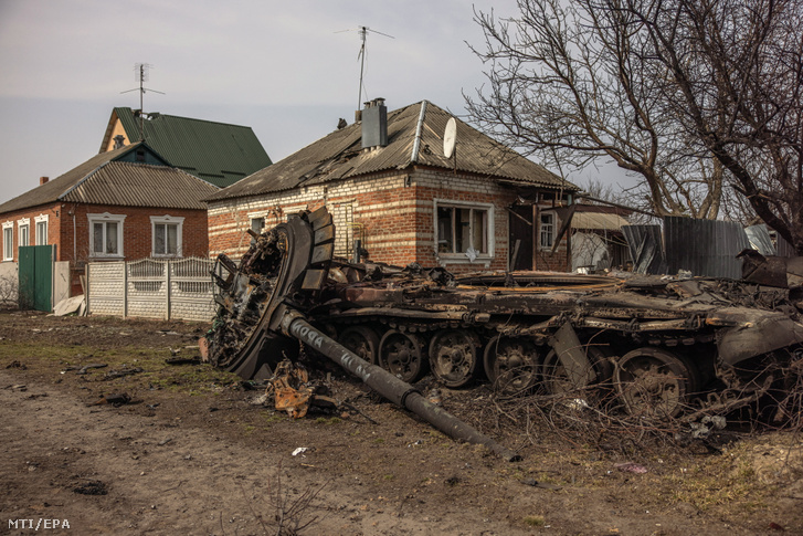 Megrongálódott orosz tank áll egy ház közelében Mala Rohan településen Harkivtól délkeletre 2022. március 31-én