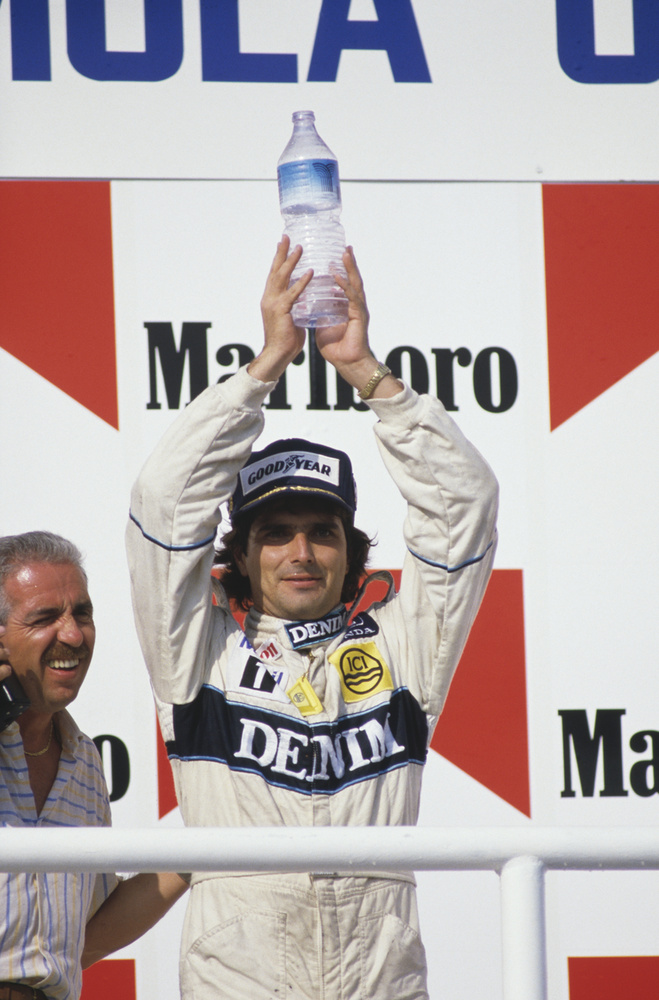 A brazil Nelson Piquet egy üveg vizet tart a magasba, miután megnyerte az első Magyar Nagydíjat