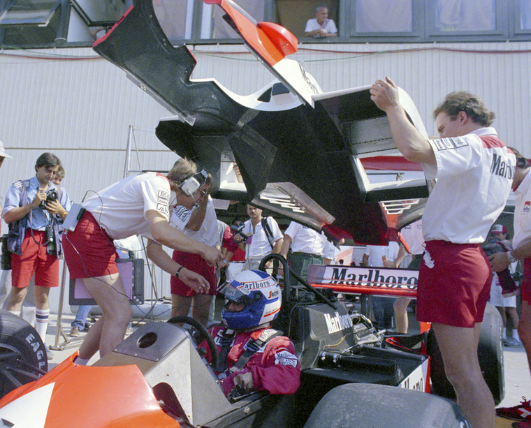 Technikusok veszik körül az autójában ülő Alain Prost francia versenyzőt a depó előtt az első Forma-1 Magyar Nagydíjon, a Hungaroringen, a mogyoródi versenypályán