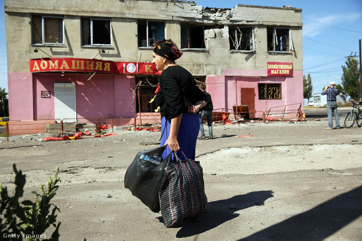 Egy nő áll egy lerombolt kávézó közelében Mariupolban, miután 2014. szeptember 7-én az oroszok által támogatott szeparatisták heves lövöldözést hajtottak végre a városban