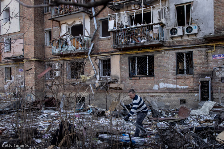 Egy férfi egy rakétatámadásban megsemmisült lakóház előtt 2022. március 18-án Kijevben
