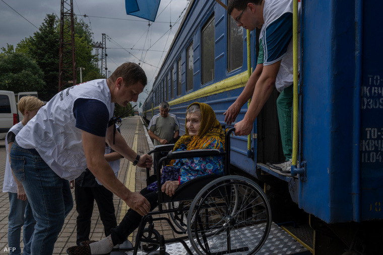 Egy idős kerekesszékes nőnek segítenek felszállni egy menekültek számára indított  vonatra Donyeck régióban, a pokrovszki  vasútállomáson, 2022